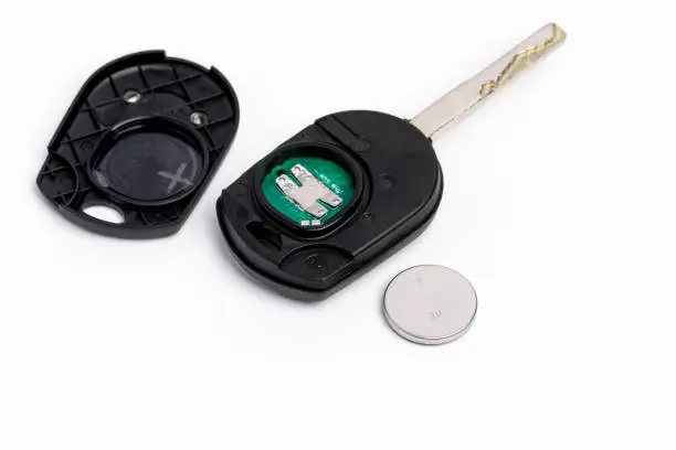 Disassembled car key fob showing the CR2032 coin battery and circuit board
